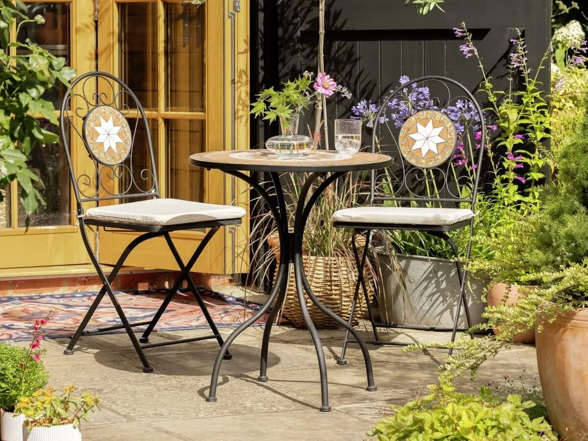 Round metal bistro table with a pair of matching chairs