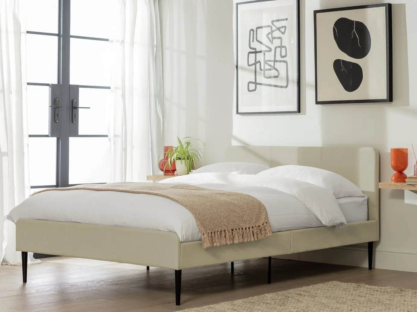 Cream fabric upholstered double bed with black tapered legs