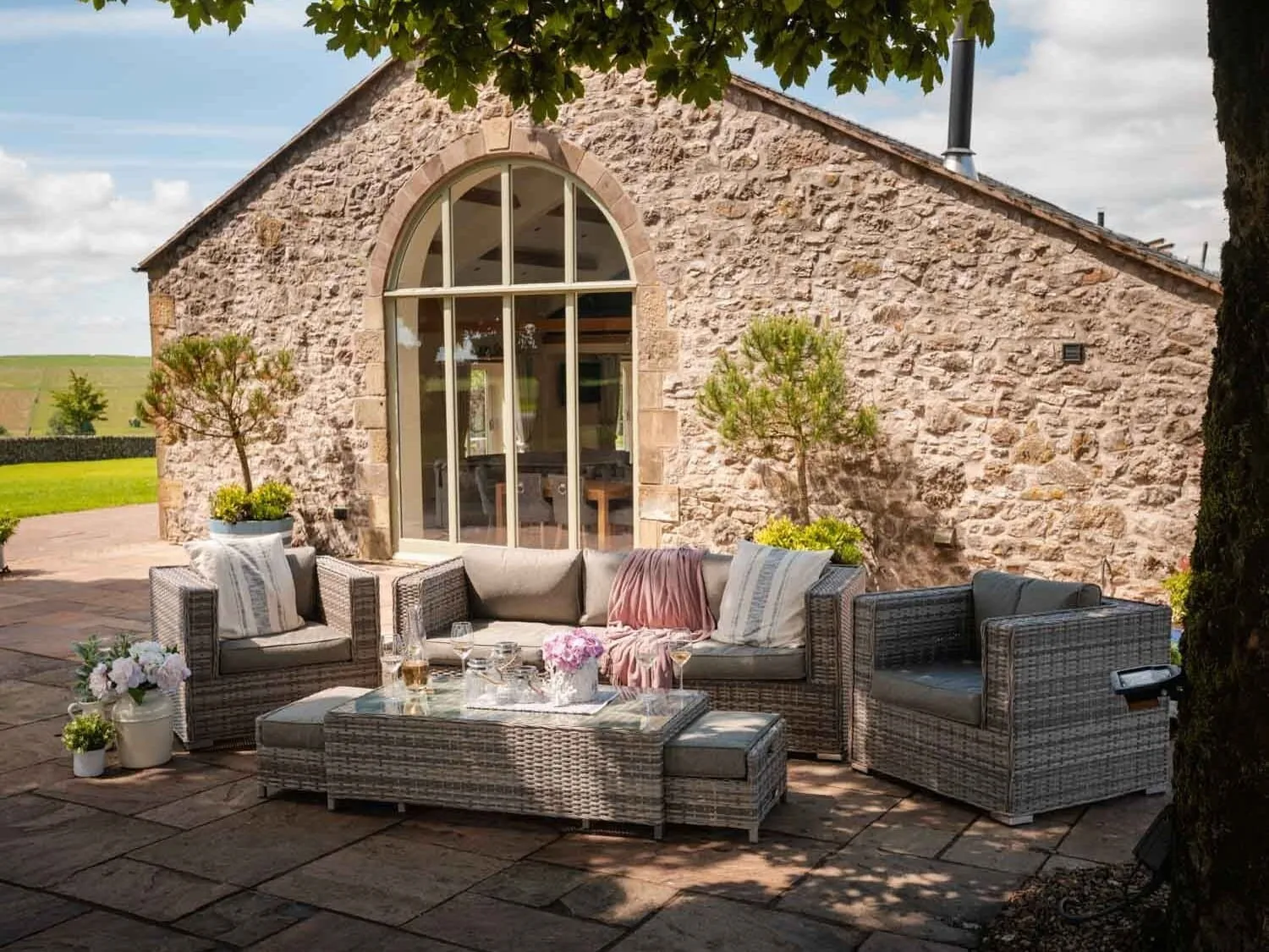 3-seater rattan outdoor sofa and two matching chairs, a rattan table and two rattan stools