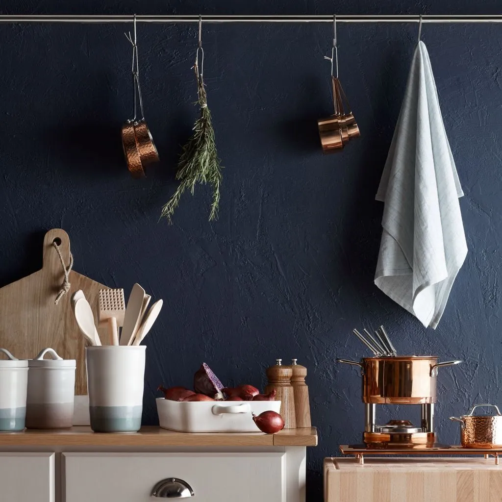 Copper accessories in a dark blue painted kitchen