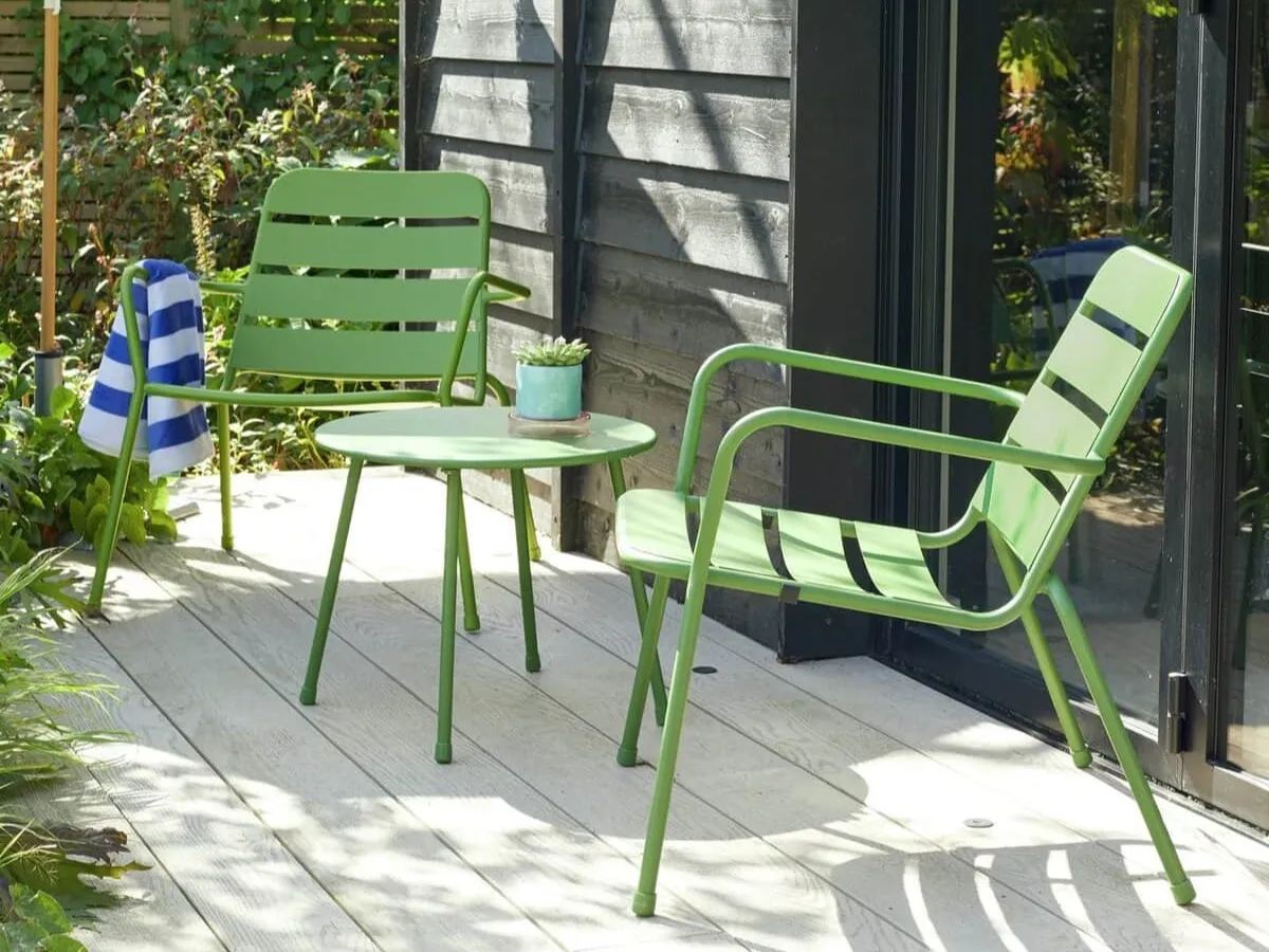 Two green metal garden chairs and a matching round coffee table