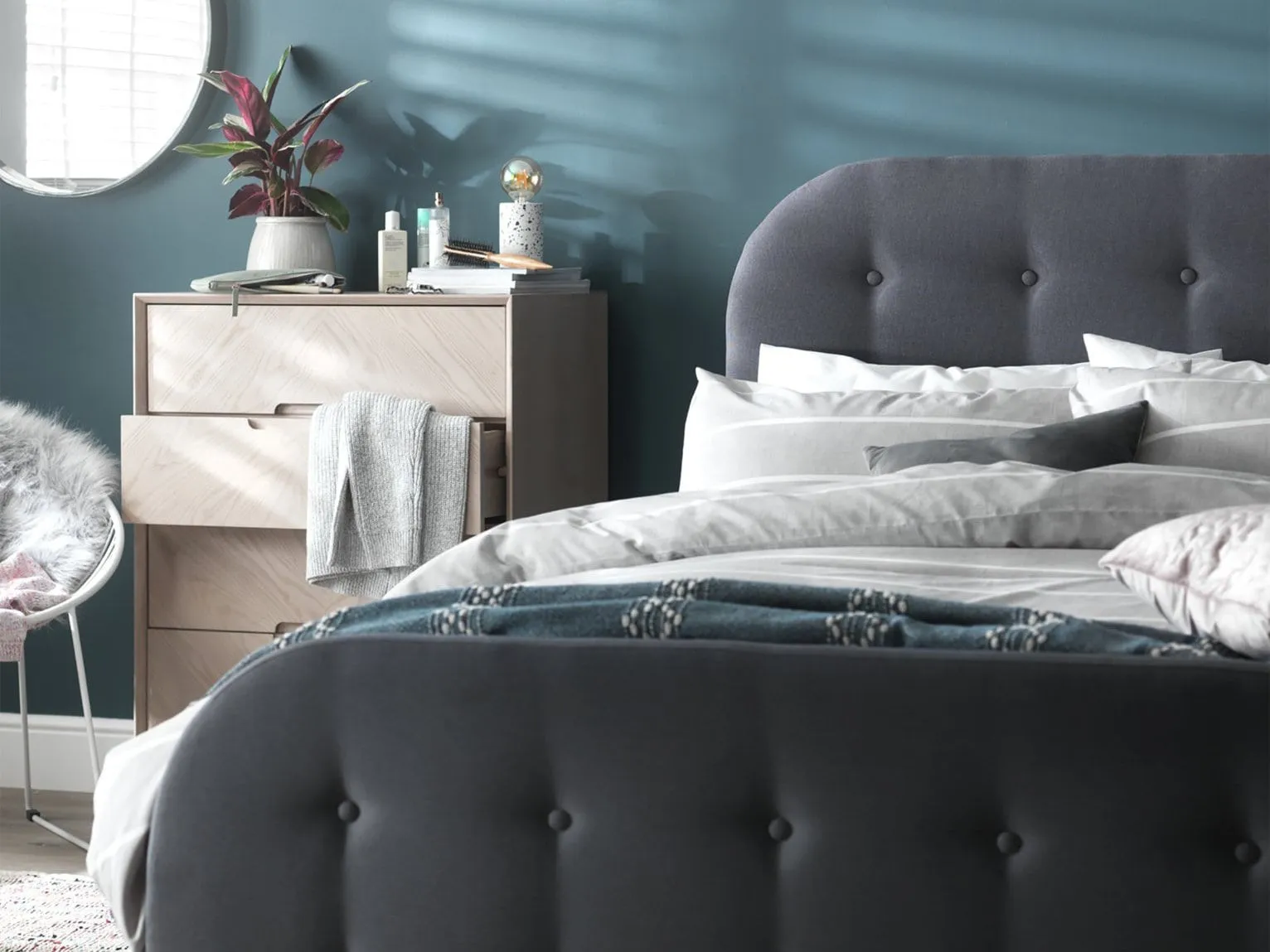 Grey fabric upholstered single bed with buttoned head and foot board