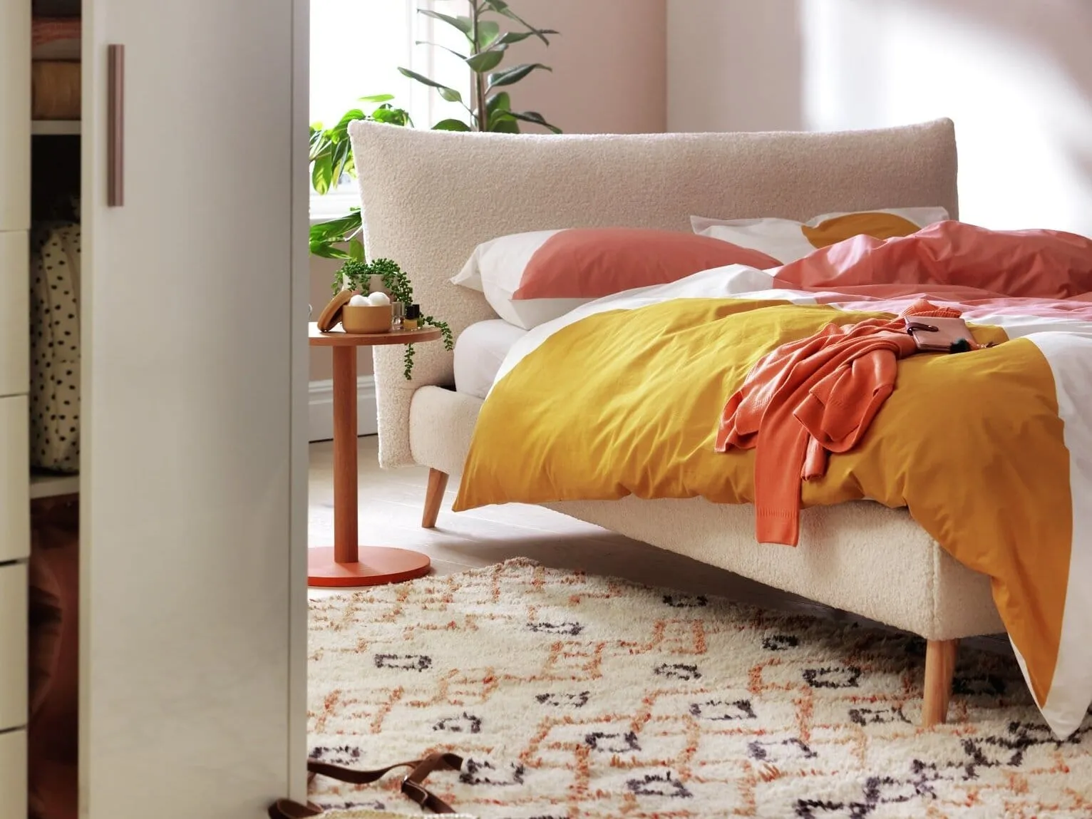 Cream boucle fabric bed with large pillow-style headboard
