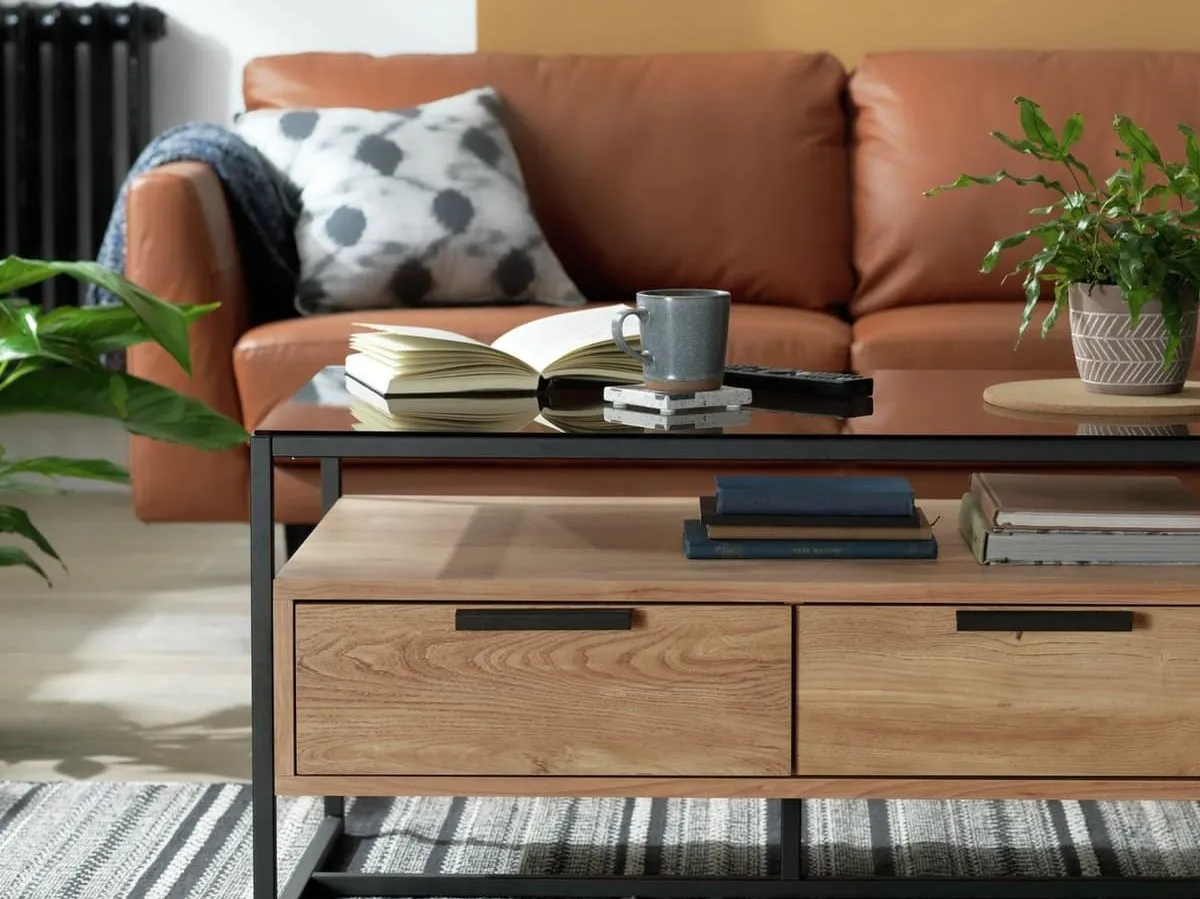 Industrial-style oak coffee table with two drawers, a glass top and black metal frame