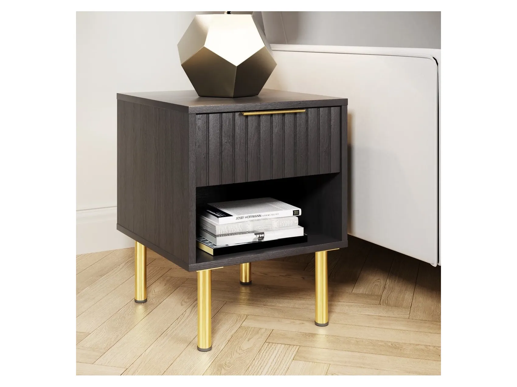 Black side table with grooved detailing and gold coloured legs
