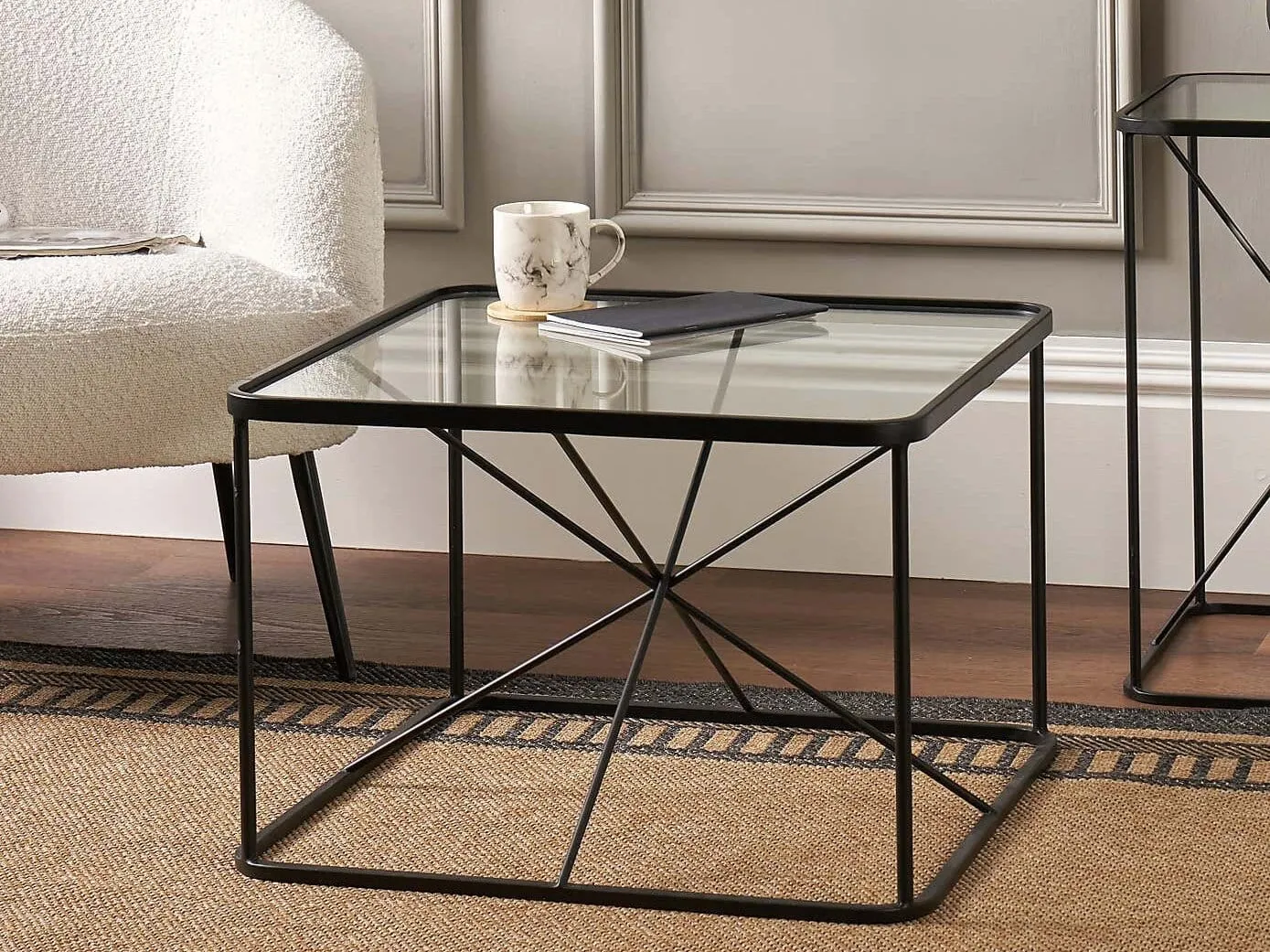 Black square coffee table with metal frame and glass top