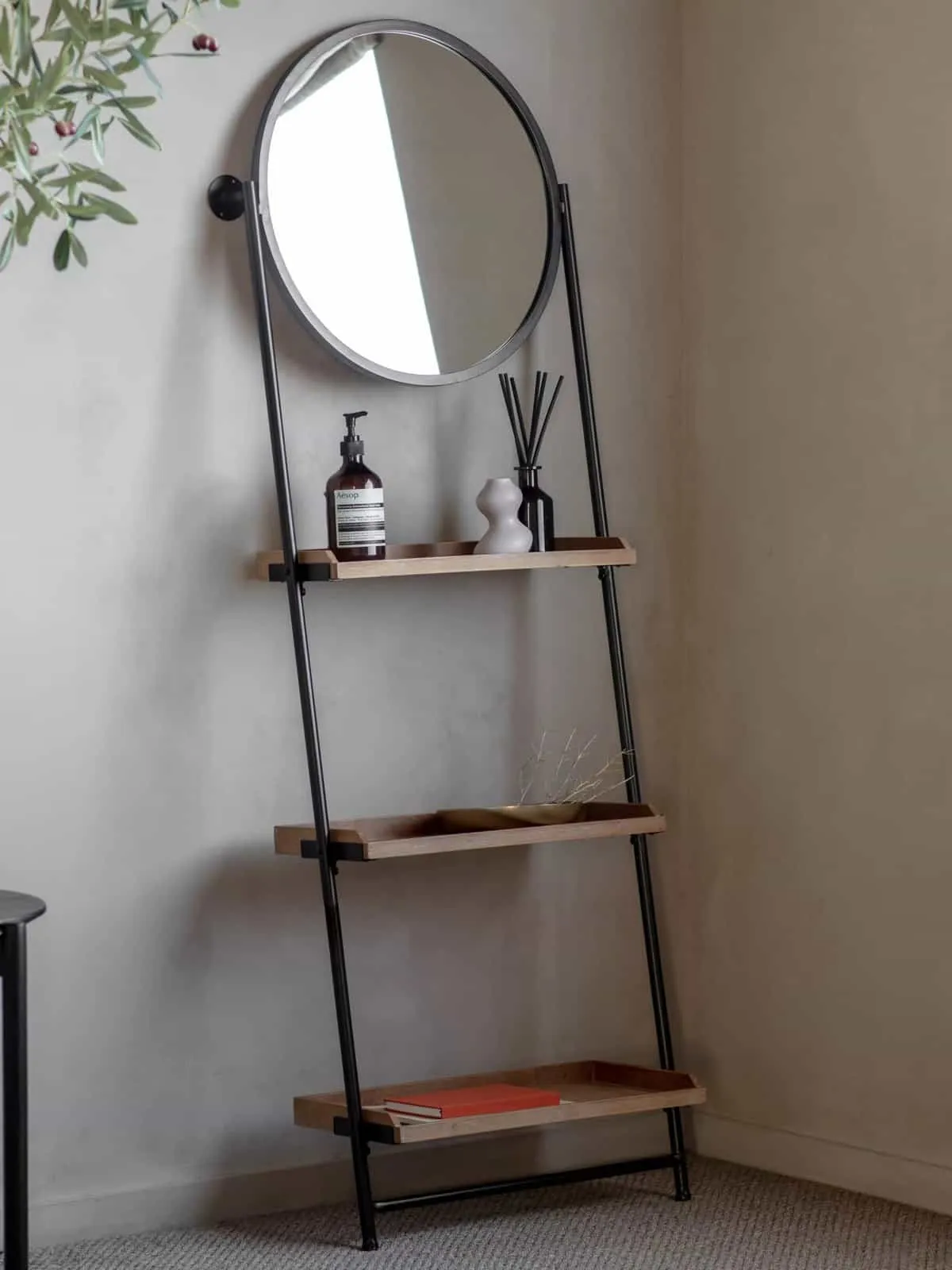 Black metal frame with 3 wooden shelves and a large round mirror