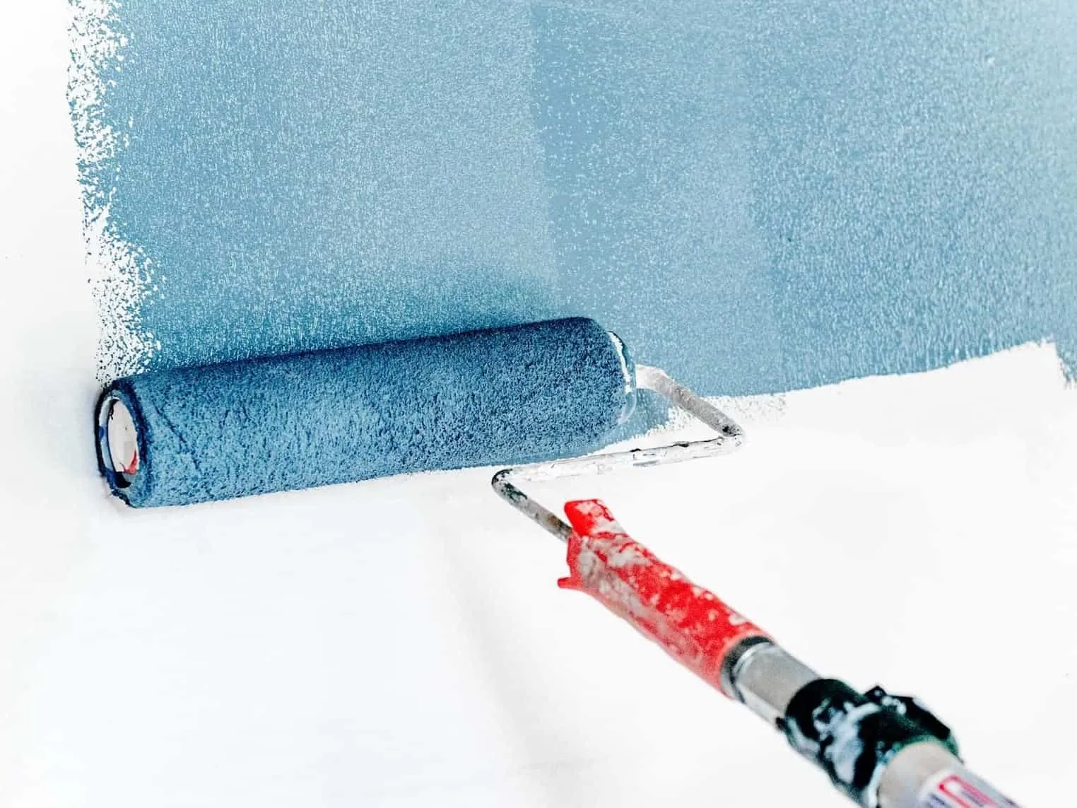 Painting a wall blue with a roller