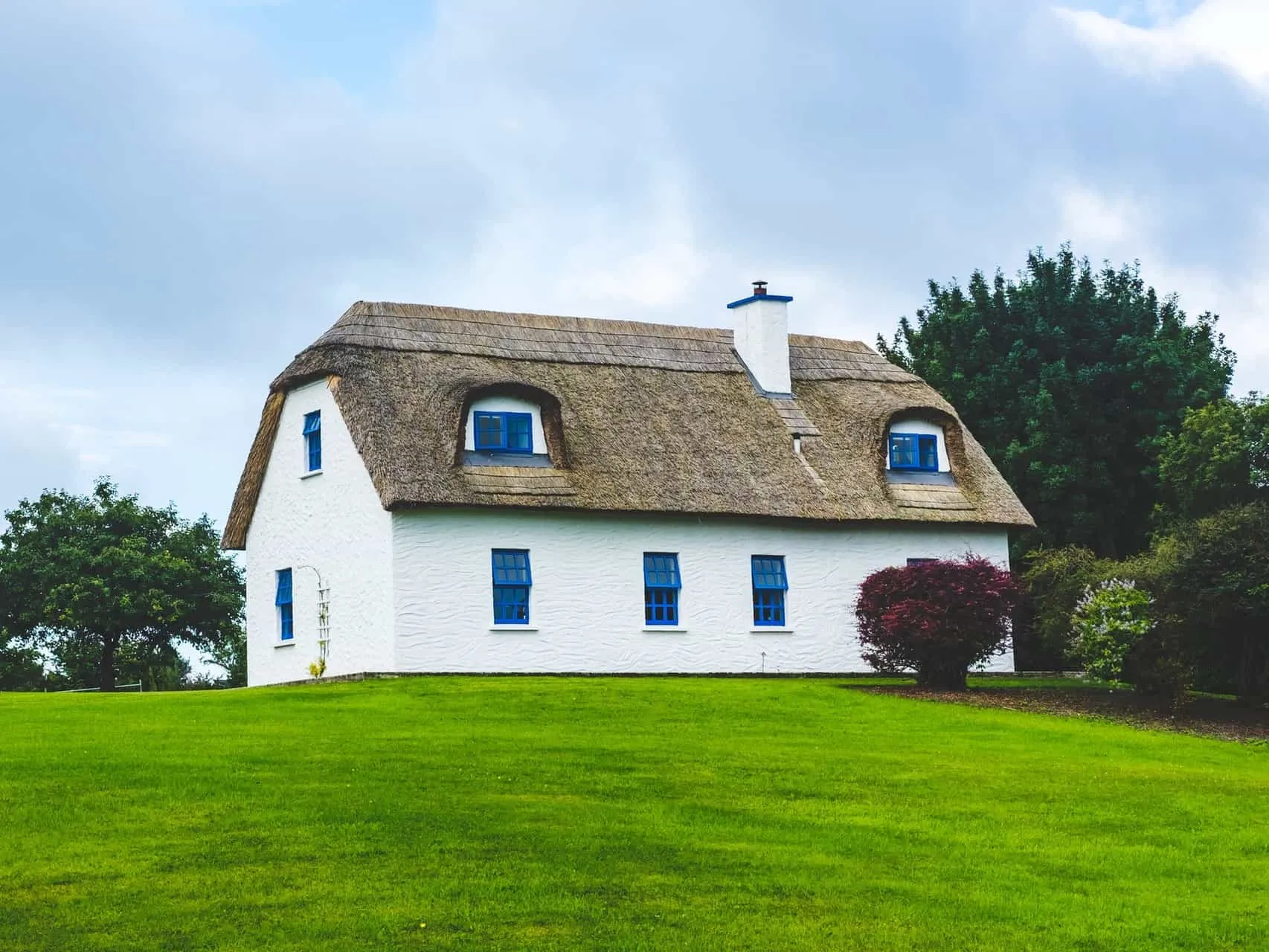 Thatched cottage with large green lawn
