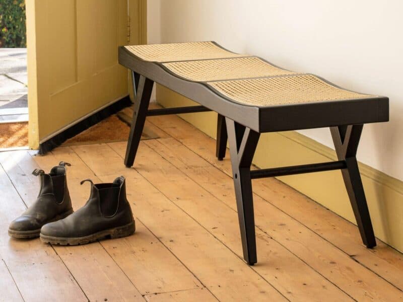 Black frame bench with woven cane seat