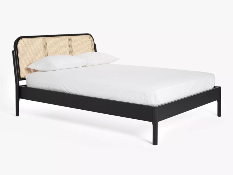 Black painted bed frame with rattan headboard