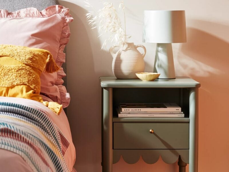 Green-painted bedside table with scallop detailing