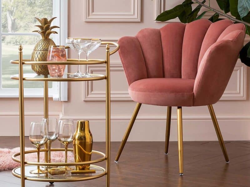 Gold coloured drinks trolley and pink velvet chair