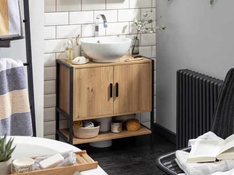 Industrial-style bathroom cabinet with black metal frame and oak finish doors