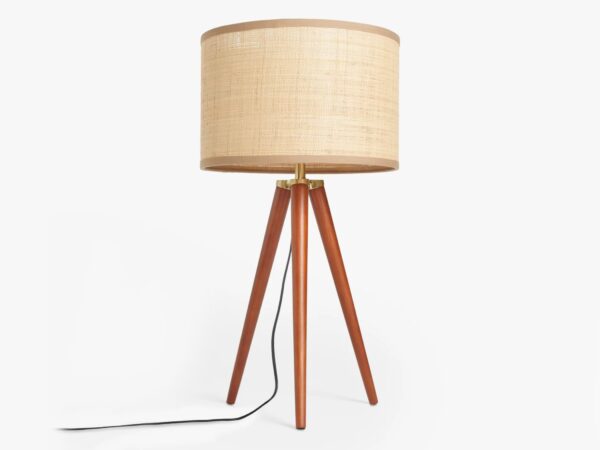 Tripod style table lamp with walnut finish legs and woven raffia shade