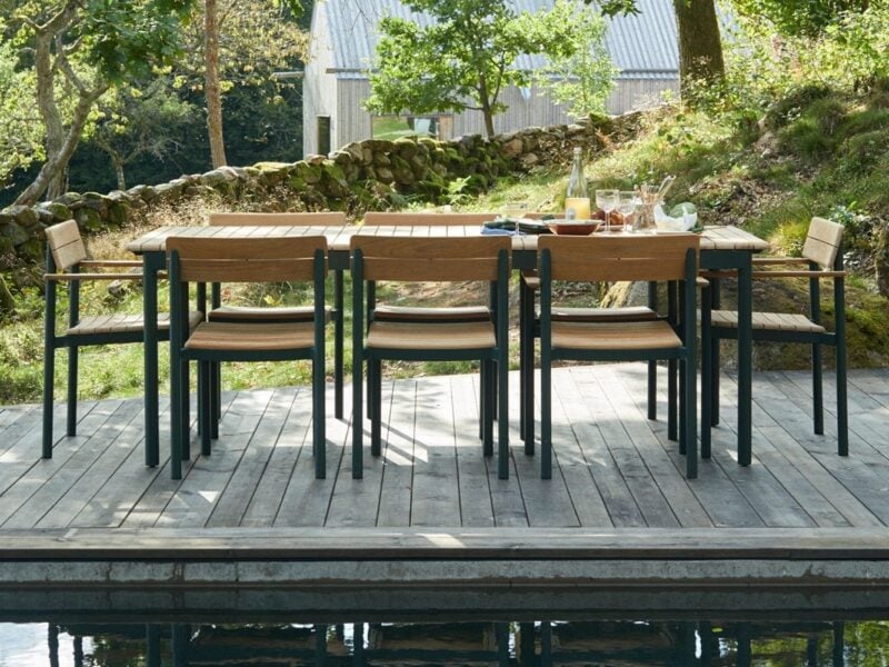 Teak outdoor dining table with green-painted frame and matching chairs 