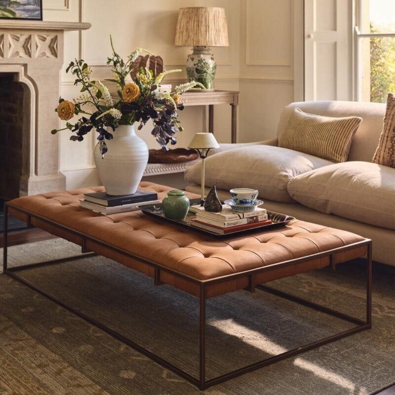 Brass coloured frame ottoman coffee table with buttoned leather upholstery