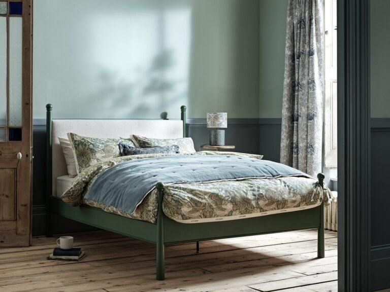 Green-painted bed frame with upholstered headboard