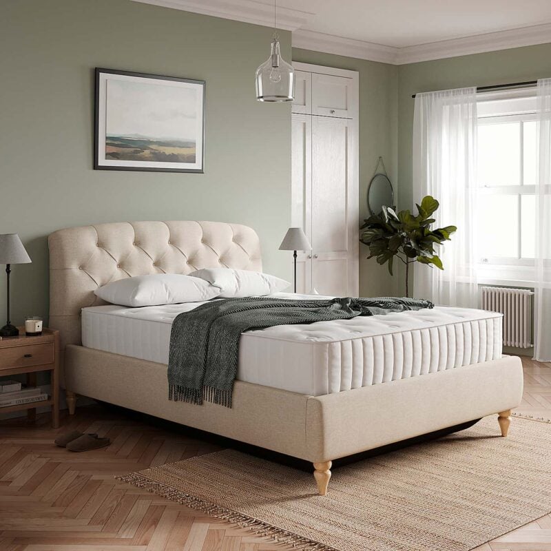 Natural fabric upholstered bed frame with buttoned headboard and round wooden feet