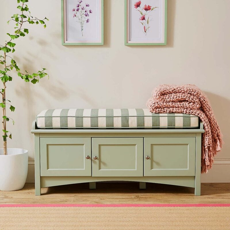 Green-painted storage bench with striped cushion seat
