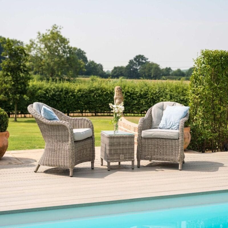 2 rattan outdoor armchairs and a matching bistro table